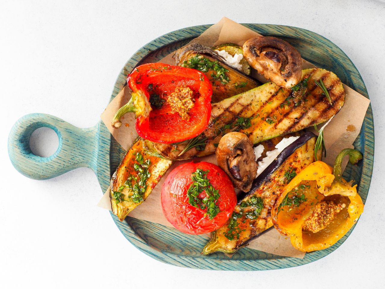A colorful assortment of grilled vegetables on a wooden board, captured from above.